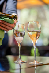 Pour white wine on summer terrace
