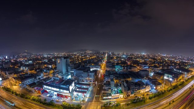 Panoramic skyline of Lima city from above with many buildings aerial night timelapse. Poor houses with hills on a background. Traffic on streets and Via Expresa highway. Lima, Peru