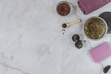 On a gray background are accessories for Spa self-care: body scrub, ground coffee, lavender soap, Terry towels for face and body