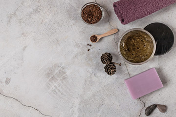 On a gray background are accessories for Spa self-care: body scrub, ground coffee, lavender soap, Terry towels for face and body