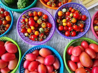 High Angle View of Red Tomatoes and Small Berries in Baskets for Sale