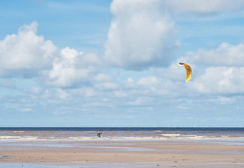A man in the ocean kite surfing against a beautiful epic blue sky. kite surfing is adrenalin...