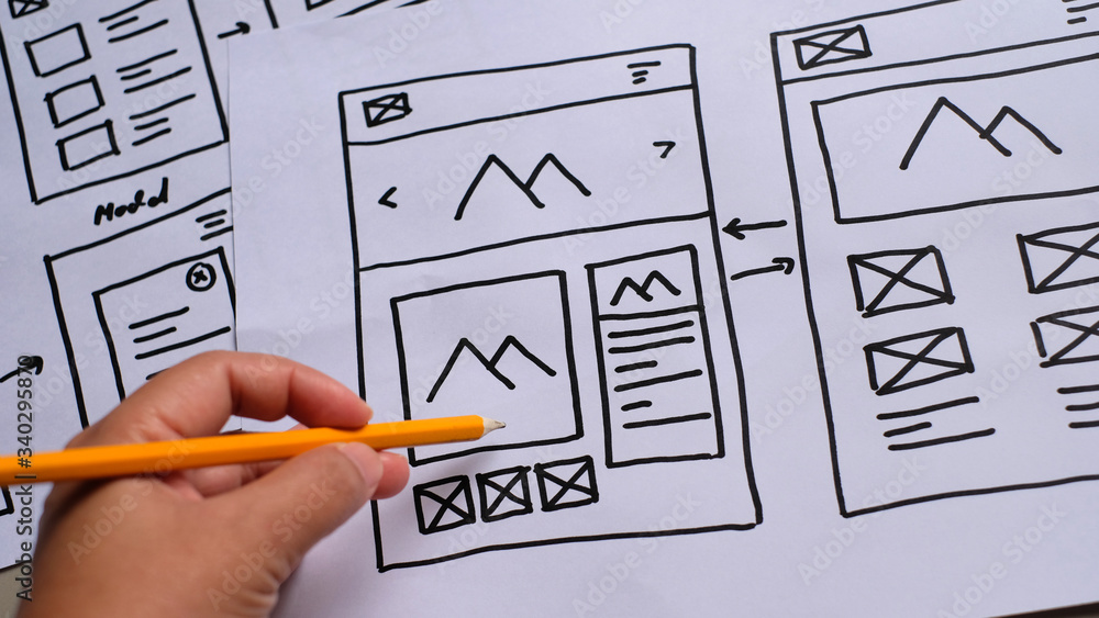 Sticker user experience design, desk with paper sketches for mobile interface.