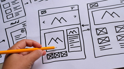 User experience design, desk with paper sketches for mobile interface.
