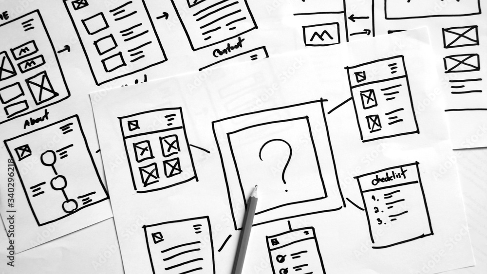 Sticker user experience design, desk with paper sketches for mobile interface.