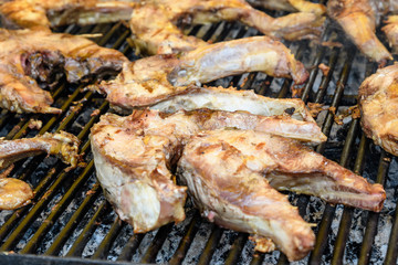 Close up of large portion of grilled fish on a large black pan at a street food festival, ready to eat healthy seafood, beautiful orange monochrome outdoor background
