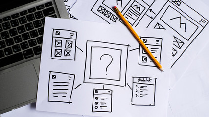 User experience design, desk with paper sketches for mobile interface.
