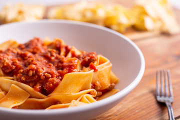 Tagliatelle with Bolognese ragu. Italian traditional tagliatelle dish with tomato and beef sauce. Rustic food, lunch with family.