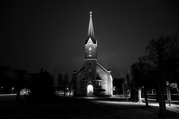 Beautiful view of small lovely local church in late evening with iluminated lights.