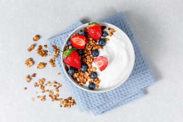 Homemade oatmeal granola bowl with greek yogurt, berries, honey and nut