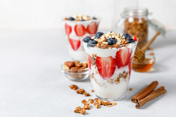 Granola parfait with greek yogurt, oat cereal, fresh berries, honey in glass jar