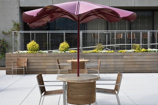 Restaurant's Outdoor Plaza With Table, Chairs, And Umbrella