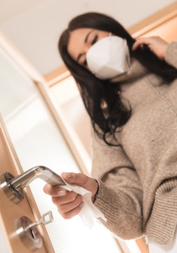 Detail of woman hand cleaning handle, using antibacterial wipe. Covid-19 home isolation and hygienic prevention.