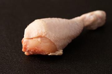 Fototapeta na wymiar Raw chicken leg on black background 