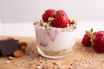 Yogurt with oat, strawberries, chocolate and almonds. Healthy and nutritious snack. Oatmeal yogurt, good protein food for muscles.
