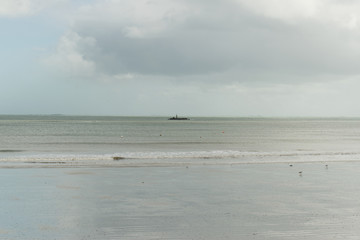 Fototapeta na wymiar Un récif signalé par une balise au large de la Plage de Langor à Loctudy dans le Finistère en Bretagne