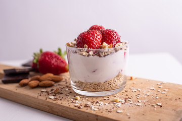 Yogurt with oat, strawberries, chocolate and almonds. Healthy and nutritious snack. Oatmeal yogurt, good protein food for muscles.
