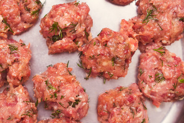 Prepared raw lumps of minced meat on a metal texture. Close up food background,