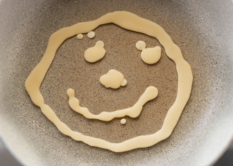 Baking dough in a pan in the shape of a smiling face. The concept of a good morning and a pleasant Breakfast. Top view.
