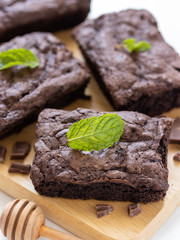 Top view of chocolate brownies on wooden board on white table, homemade sweet and dessert concept