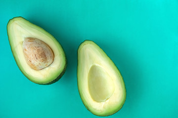 two halves of avocado on a green background