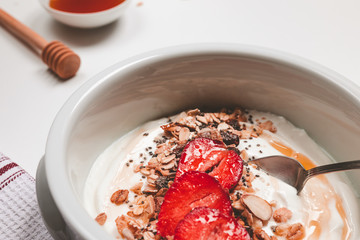 closeup of yogurt bowl with muesli strawberries chia seeds and honey
