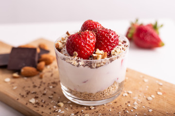 Yogurt with oat, strawberries, chocolate and almonds. Healthy and nutritious snack. Oatmeal yogurt, good protein food for muscles.