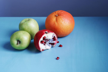 Colorful and juicy horizontal photo of fruits on a blue table with a gray background with empty place for text at the top. Healthy, healthy vegetarian food.