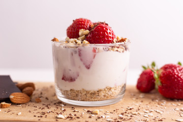 Yogurt with oat, strawberries, chocolate and almonds. Healthy and nutritious snack. Oatmeal yogurt, good protein food for muscles.