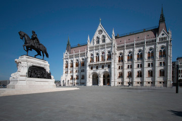 Obraz premium Hungarian Parliament building with a state honoring Gyula Andrassy on horseback.