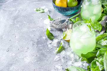 Basil smash gin alcoholic cocktail. Long alcohol drink recipe with fresh basil leaves and limes,...