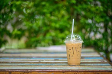 Iced espresso coffee placed on a wooden table in the garden