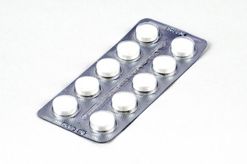 blister with white pills on the white background
