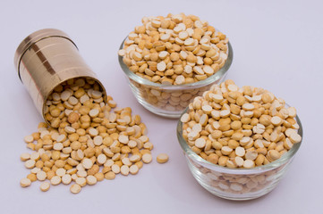 Group of a healthy roasted gram in a bowl with brass measuring jar on a white background
