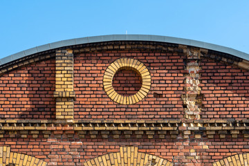 Decorative circle in old brick facade made by red and beige clinker