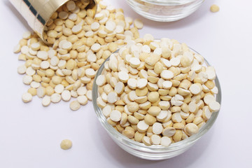 Group of a healthy roasted gram in a bowl with brass measuring jar on a white background