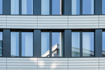 Modern facade of office buildings with stainless steel elements and reflecting windows