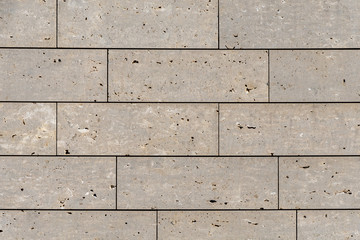 Modern stone facade texture of smooth natural stone plates at modern building facade in warm sunlight