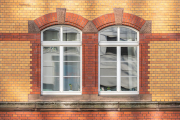 Old building facade red and beige dutch clinker surrounding windows as a frame