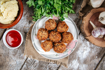 Top view on appetizing cooked homemade meatballs with meat, rice and vegetables, tefteli, with mashed potatoe, red sauce and garlic, horizontal