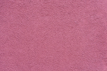 Texture of pink or purple painted and plastered building facade