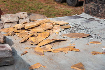 Stone rubble scraps loaded onto a trailer to be hauled off of a patio construction job site