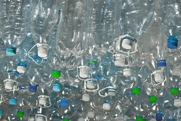 Many plastic bottles are dumped. Texture of transparent bottles of water. Concept of environmental pollution and environmental problems. Dirty plastic closeup.