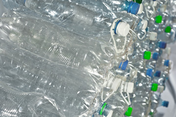 Many plastic bottles are dumped. Texture of transparent bottles of water. Concept of environmental pollution and environmental problems. Dirty plastic closeup.