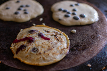Three deliciously fresh blueberry pancakes cooking on the simmering plate of a traditional AGA cooker