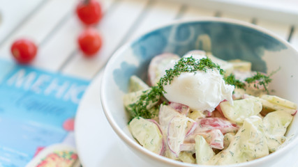 bowl of fresh vegetable salad with sour cream and poached egg