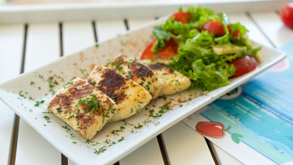 plate with grilled cheese and fresh vegetables 