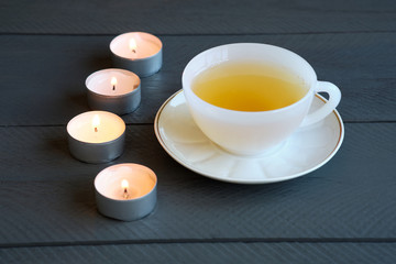 Fototapeta na wymiar A cup with green tea and candles