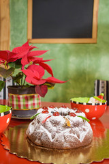 Naklejka na ściany i meble black cake covered in snow sugar and cherries. In the background a frame,