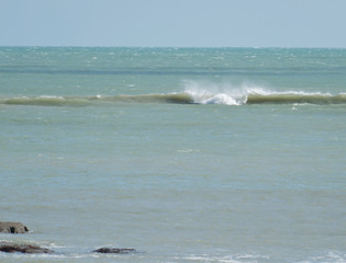 Une vague s'approche du rivage avec force et puissance et va s'échouer sur la plage du village de pêcheurs de Loctudy en Bretagne dans le Finistère